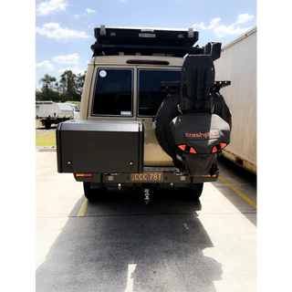 Back view of a vehicle with a spare tire and Thorburns BBQ 2.0 on a concrete surface – Thorburns LC75/78 Rear Bar