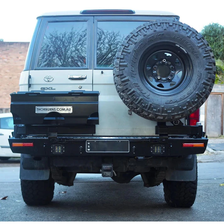 Thorburns LC76 Rear Bar – back view of a white Toyota Land Cruiser with a spare tyre mounted on the back, parked on a street.