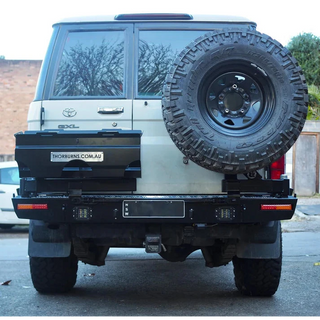 Thorburns LC76 Rear Bar – back view of a white Toyota Land Cruiser with a spare tyre mounted on the back, parked on a street.