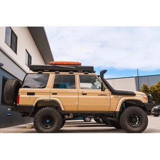 Beige LC76 with roof rack and additional equipment parked in front of a building – Thorburns LC76 Rear Bar