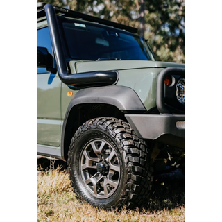 Green Suzuki Jimny with snorkel and bumper on grassy terrain – Torqit 3.5" Stainless Steel Snorkel (Matte Black) for Suzuki Jimny (JB74 / JC74 XL)
