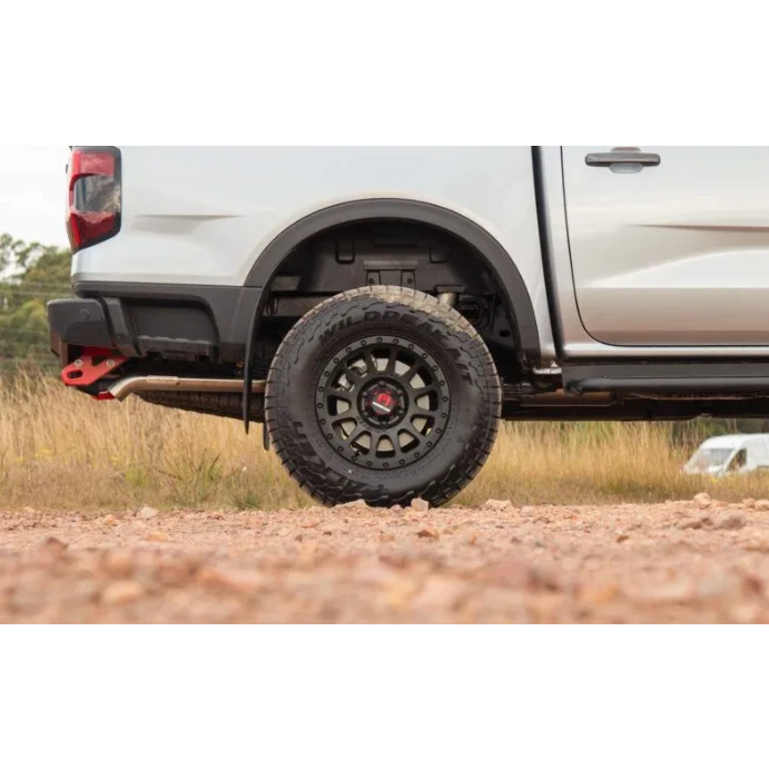 Close-up of a white truck with off-road tires on a dirt road – Torqit DPF Back 3″ Performance Exhaust for Next-Gen 3.0L V6 Ford Ranger 2022+