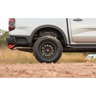 Close-up of a white truck with off-road tires on a dirt road – Torqit DPF Back 3″ Performance Exhaust for Next-Gen 3.0L V6 Ford Ranger 2022+
