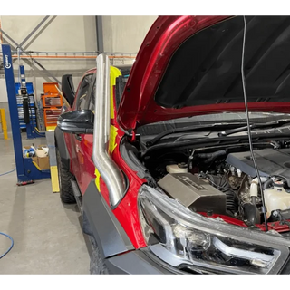 Red Toyota Hilux in a workshop – Torqit Stainless Steel Airbox (Matte Black) for Toyota Hilux 2.8L