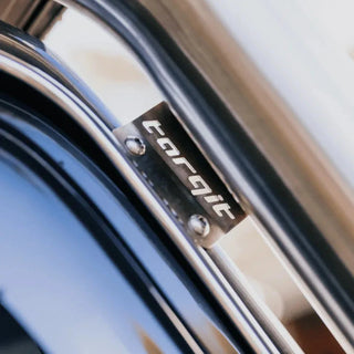 Close-up of the stainless Torqit badge plate bolted to the snorkel body where it meets the A-pillar, the brand name cut into the brushed metal