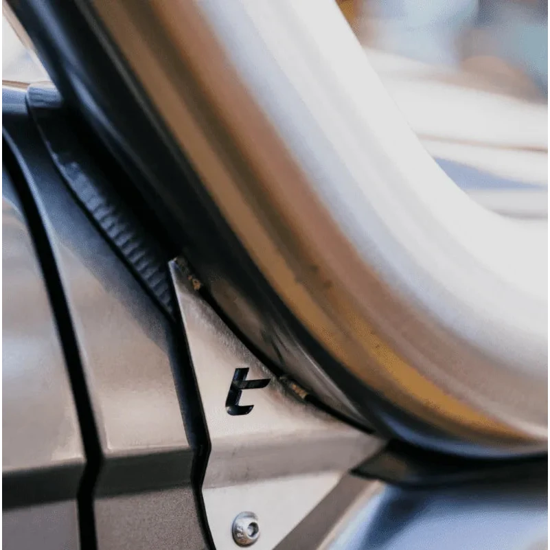 Close-up of the base of a stainless snorkel where it enters the guard, showing the welded seam, the rubber seal along the edge and the small Torqit mark stamped in the panel