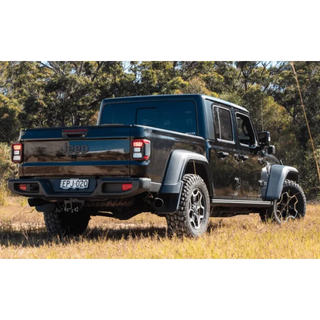 Black Jeep truck in a natural setting with trees and grass – Torqit Twin Exit 3″ Cat Back Performance Exhaust for Jeep Gladiator 2020+