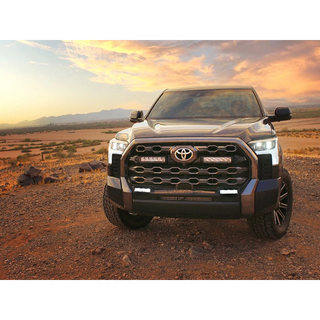 Toyota truck on a dirt road with a sunset in the background