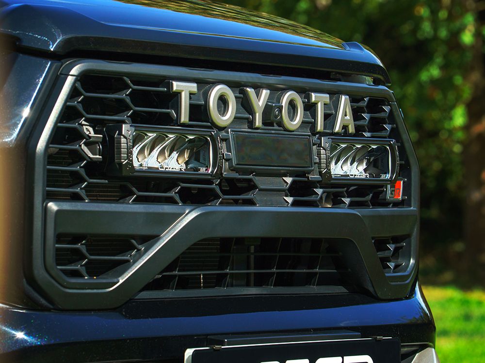 Close-up of a Toyota vehicle grille with Lazer Lamps Toyota Hilux GR Sport (2024+) Grille Kit