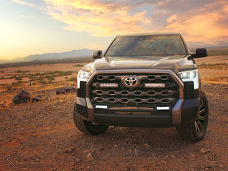 Toyota truck on a dirt road with a sunset in the background