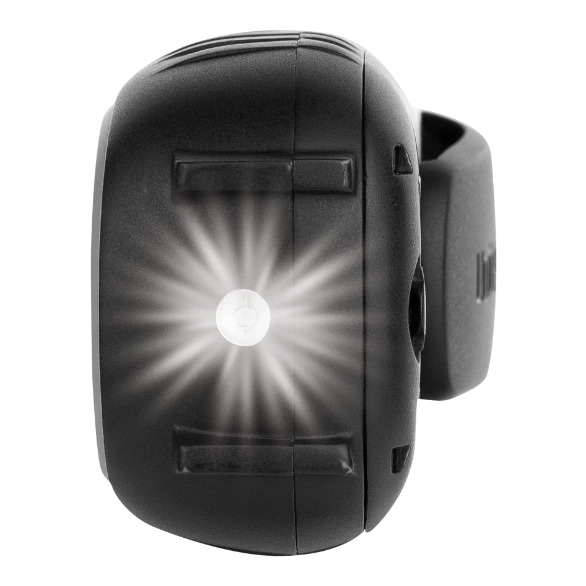The torch end of a Uniden UH620 handheld UHF radio, the white LED lit in the moulded housing with the belt clip visible behind