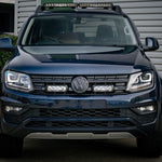 Front view of a black Volkswagen SUV with visible logo in a parking lot with Lazer Lamps Grille Kit for VW Amarok V6 (2016–2022)