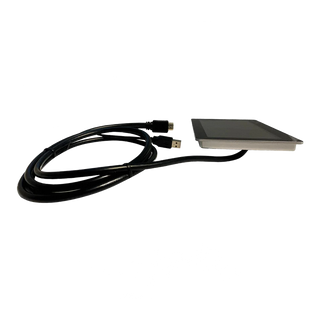 Victron GX Touch 50 seen at a low angle showing how thin the flush-mount panel is, with its stainless bezel and the supplied USB and HDMI lead coiled alongside