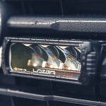 Car fog light with 'Lazer' branding on a vehicle interior.