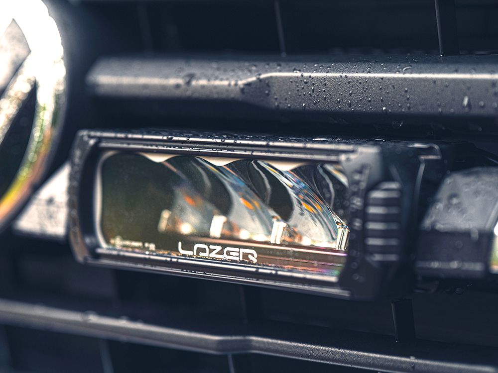 Car fog light with 'Lazer' branding on a vehicle interior.