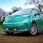 Turquoise Volkswagen car parked on a road with trees in the background with Lazer Lamps Grille Kit for VW ID Buzz (2025+)