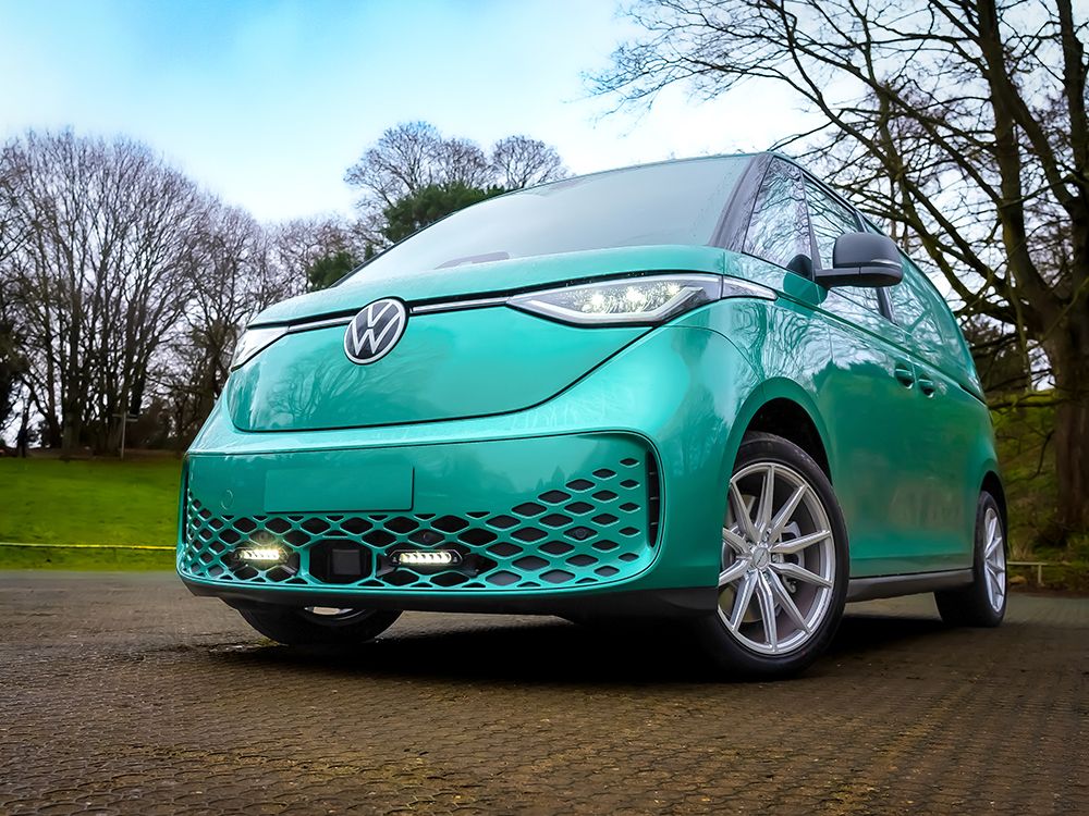 Turquoise Volkswagen car parked on a road with trees in the background with Lazer Lamps Grille Kit for VW ID Buzz (2025+)