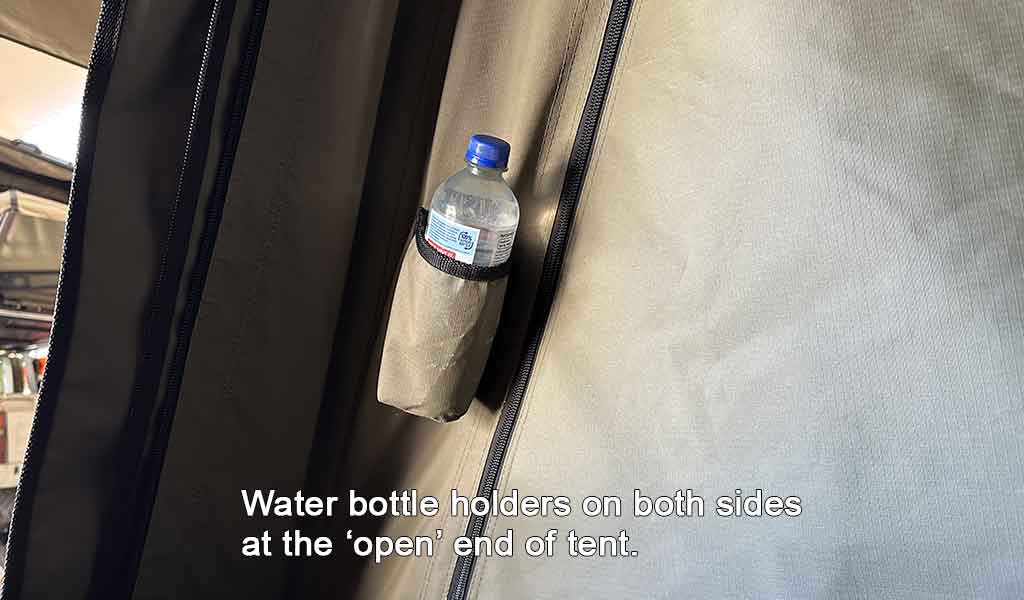 Water bottle holder on a tent with text indicating it's at the 'open' end of the tent.