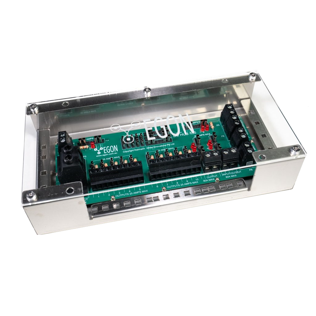 The EGON DC Hub fitted in its aluminium bracket with the clear polycarbonate cover screwed down, so the fuse banks, LEDs and screw terminals stay visible while protected