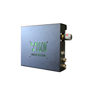 EGON Water Hub 2.0 seen from the front and side, the black steel case with the green EGON Water Hub logo on the cover, the thermostatic mixing valve with its temperature scale on the end, and the brass plumbing fittings below it
